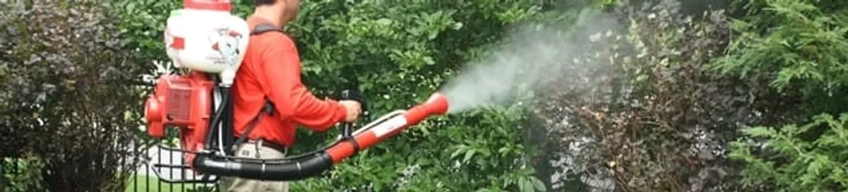 Mosquito control technician fogging shrubs and landscaping for mosquito treatment in Irvine, CA